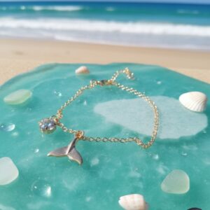 This is a gold-toned whale tail charm bracelet